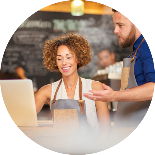 happy cafe owner smiling at profit on laptop